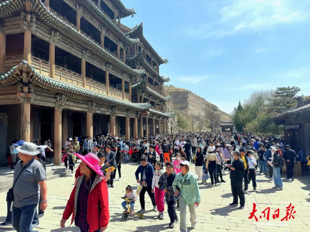 图为游客在云冈石窟感受世界文化遗产的魅力。于宏 摄 图为游客在云冈石窟感受世界文化遗产的魅力。于宏 摄