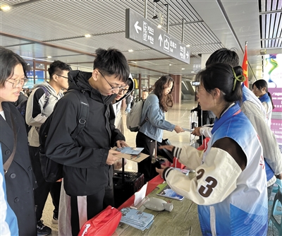 志愿者发放旅游手册。　孙露摄