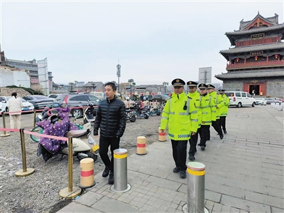 图为城管执法人员在古城内巡逻.张鑫摄