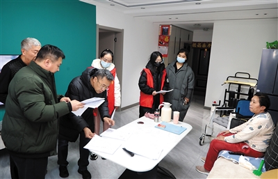 图为工作人员为残疾人上门做鉴定。韩堃摄
