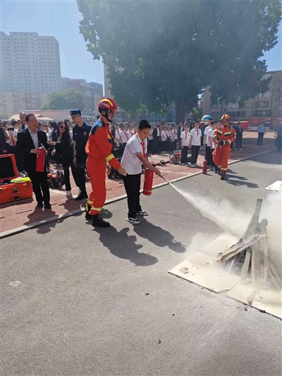 平城区47校学生学习如何正确使用灭火器。丁亚琴摄