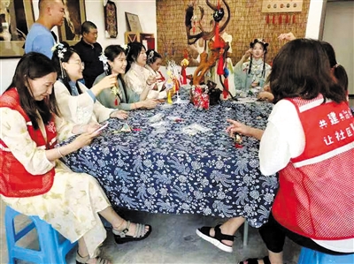 社区工作人员与居民们一起制作香囊。孙露摄