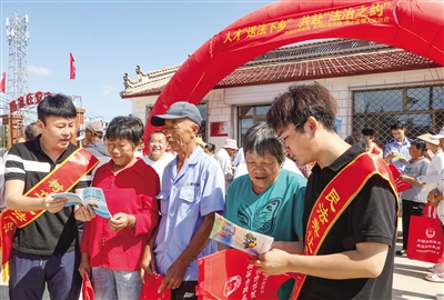 图为法律工作者为村民解读相关法律法规、提供法律咨询。韩堃摄