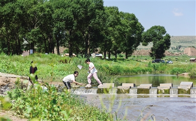 图为孩子们在饮马河畔嬉戏玩水.于宏摄