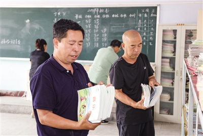 平城区49校工作人员正在清点新学期教材。韩堃摄