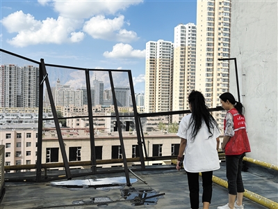永昌里社区工作人员检查楼顶老化栏杆。段雨萌摄