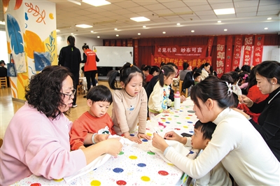 家长和孩子一起折布体验扎染艺术。韩堃摄