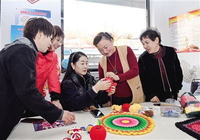 图为云州区吉祥里社区“巧婆娘”手工团队的妇女们在社区新时代文明实践站钩织非遗文创产品。张燕伟摄
