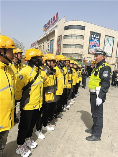 图为交警对外卖小哥进行交通安全知识宣传。尚丽摄