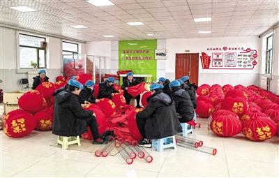 图为在瓜园村灯笼生产车间,编织合作社的妇女们正忙着制作大红灯笼。董芳摄 图为在瓜园村灯笼生产车间,编织合作社的妇女们正忙着制作大红灯笼。董芳摄