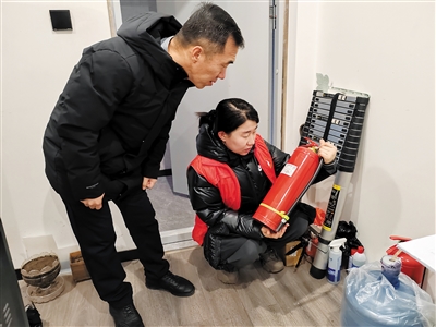 图为同兴街社区工作人员检查灭火器。郑林摄