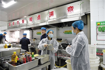 执法人员检查学校食堂后厨操作间。张鑫摄