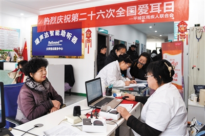 图为听障人士家属正在咨询助听器相关情况。韩堃摄 图为听障人士家属正在咨询助听器相关情况。韩堃摄