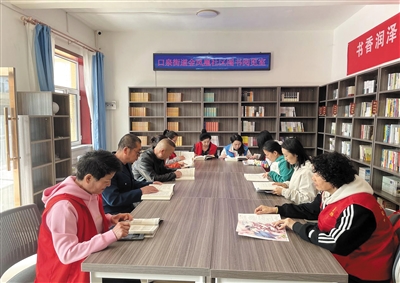 图为金凤凰社区居民在阅览室共同阅读、交流心得。申力摄