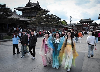 “五一”假期，大同古城内游人如织，市民、游客身着汉服、唐装等传统服饰，执团扇、擎油纸伞，在各景区景点参观游览。张燕伟摄