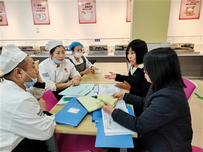 平城区18校凯德校区校领导与食堂工作人员就食堂环境卫生及餐具清洁等问题进行沟通交流。资料图片