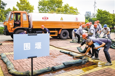 图为应急演练现场，救援队在搭建围堰。韩堃摄