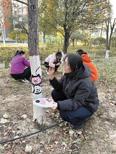 居民们纷纷拿起画笔，美化小区树干。段雨萌摄