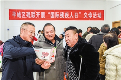 义诊活动中，工作人员解读扶残惠残政策。韩堃摄