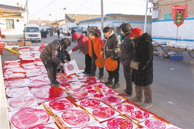 图为张留庄村红火热闹的传统大集，村民在选购年货。申力摄