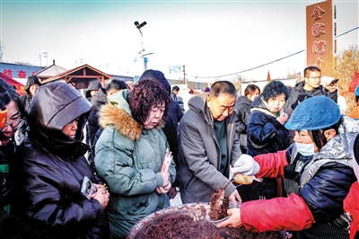 居民们有序排队领取腊八粥。韩堃摄 居民们有序排队领取腊八粥。韩堃摄