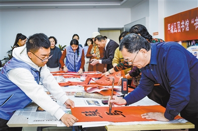 图为书法家走进平城区开源街道民懋社区挥毫泼墨，为居民书写春联。韩堃摄