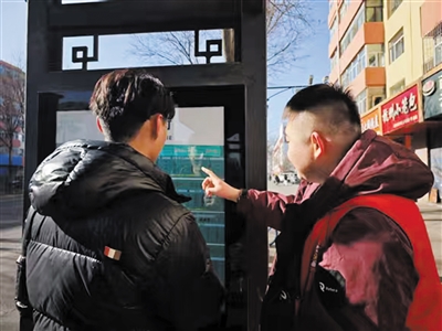 东风园社区工作人员为游客提供公交路线指引。郑林摄