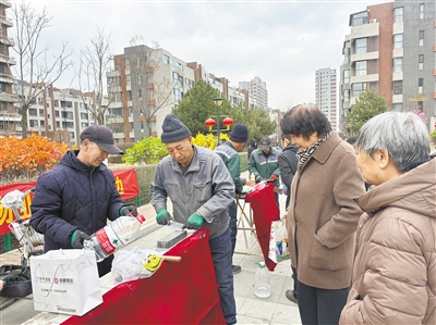 图为志愿者为华北星社区居民磨剪刀和菜刀。杨昱郁摄
