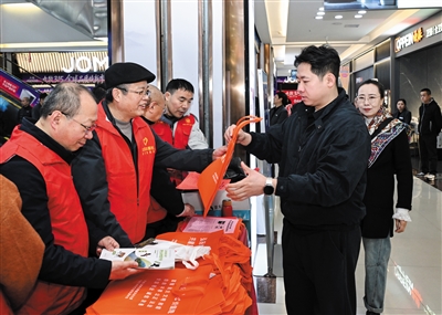 图为活动现场，大同日报社经营部门第三党支部党员们向市民发放消费维权宣传材料。张燕伟摄