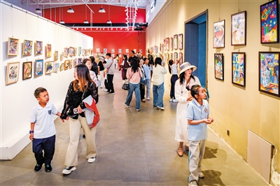 图为家长带着孩子观展。韩堃摄