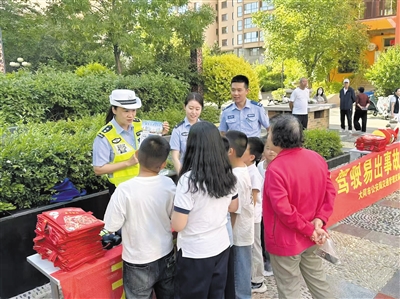 活动现场,交警为家长和孩子们讲解乘车交通安全常识。于宏摄 活动现场,交警为家长和孩子们讲解乘车交通安全常识。于宏摄