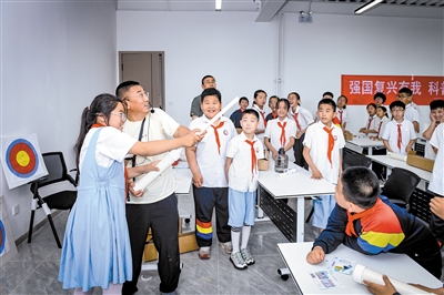 科普工作者指导青少年发射气功箭。韩堃摄