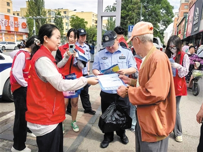街道工作人员和交警为过往群众发放宣传资料,普及安全出行法律法规和日常出行常识。郑林摄 街道工作人员和交警为过往群众发放宣传资料,普及安全出行法律法规和日常出行常识。郑林摄