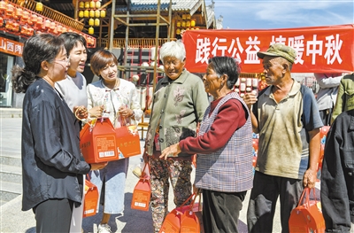 图为爱心志愿者向该村老年人发放月饼等中秋慰问品。于宏摄