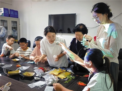 居民们老少携手，精心制作精美荷包。段雨萌摄