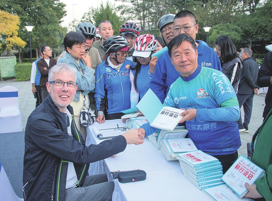 “绿色并州、低碳同行—绿色出行交流活动暨《骑行漫记》作者见面会”上，英国漫画家戴夫·沃克为读者签名留念。 山西经济日报记者 张剑雯 摄