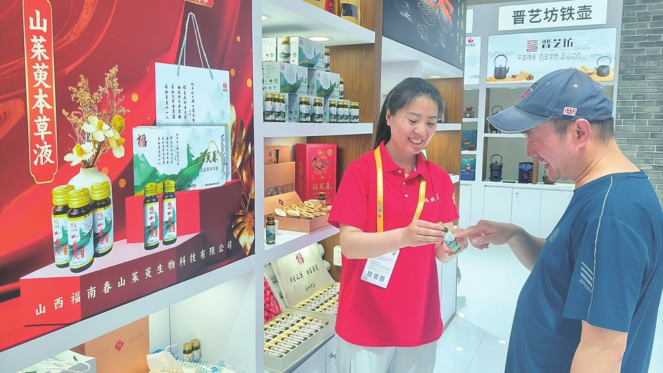 参展企业工作人员向观展者介绍产品。山西经济日报记者 姚凡 摄