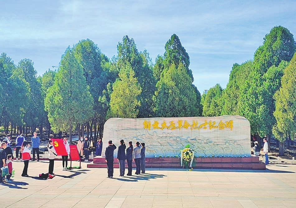 游客在解放太原革命烈士纪念碑前重温入党誓词。山西经济日报记者 康煜 通讯员 李红 摄