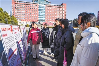 图为工作人员通过展板向学生介绍防艾知识。韩堃摄