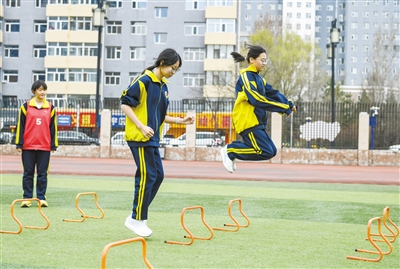 体育教师在指导初三学生进行体能和腿部力量训练。于宏摄