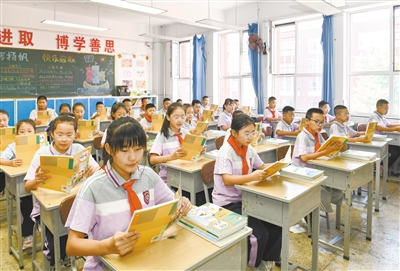 图为昨日在平城区10校，学生们一起阅读新学期课本。戎禹仁摄