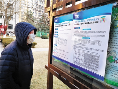 居民在社区宣传栏了解城乡居民医保缴费方式。高燕摄